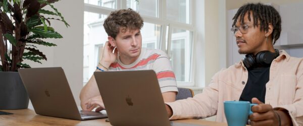 Two people working on laptops