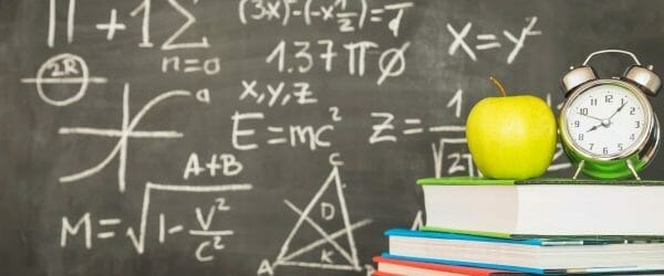 books with alarm clock near blackboard