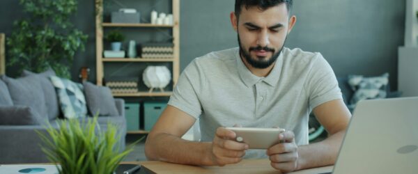 Happy Moddle Eastern man is playing video game