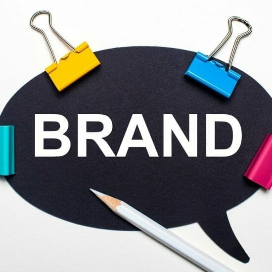 light surface multi colored paper clips white pencil black paper with words brand 1