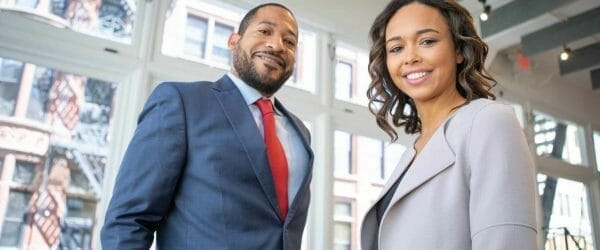 man and woman smiling inside building