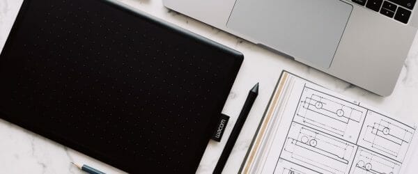 black and silver macbook pro beside black pen