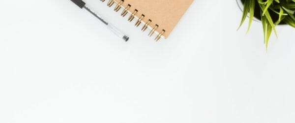 black ball point pen with brown spiral notebook