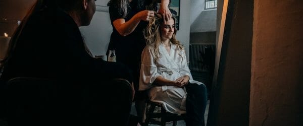 hairstylist fixing her client s hair