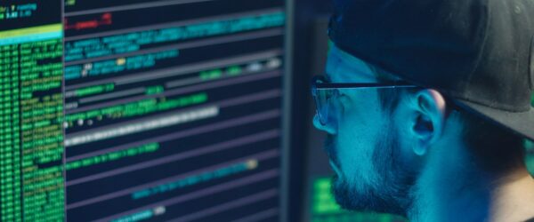 Person coding with multiple computer screens.